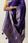 A detailed shot showing the rich, heavy gold zari weave on the pallu of the Vanya Sarees royal purple Banarasi silk saree.