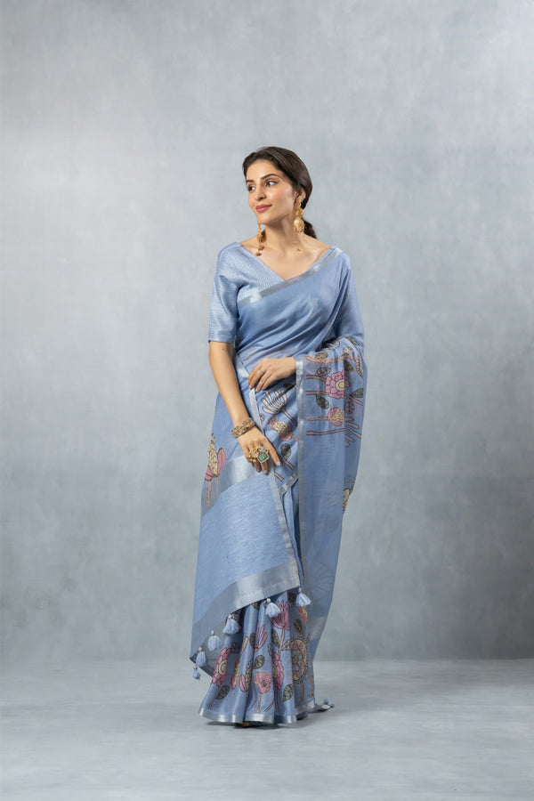 An graceful standing pose of the model in the Vanya Sarees blue floral print linen saree, perfect for a day wedding.