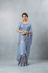 Model showcasing the complete designer look of the Vanya Sarees periwinkle blue printed linen saree with its matching blouse.