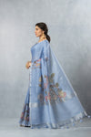 An elegant side profile of the model wearing the Vanya Sarees blue linen cotton saree, showcasing its beautiful drape and artistic print.