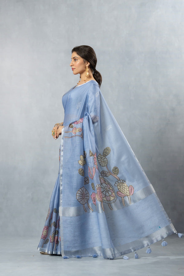 An elegant side profile of the model wearing the Vanya Sarees blue linen cotton saree, showcasing its beautiful drape and artistic print.