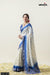 Model smiling in a full view of the Vanya Sarees white and royal blue tie-dye Chanderi silk saree with a designer blouse.