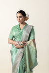 A close-up of the model in a Vanya Sarees Chanderi silk saree, highlighting the broad silver zari border and collared blouse.