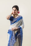 A beautiful side profile of the model in a Vanya Sarees Chanderi silk saree, highlighting the blue tie-dye and woven zari border.