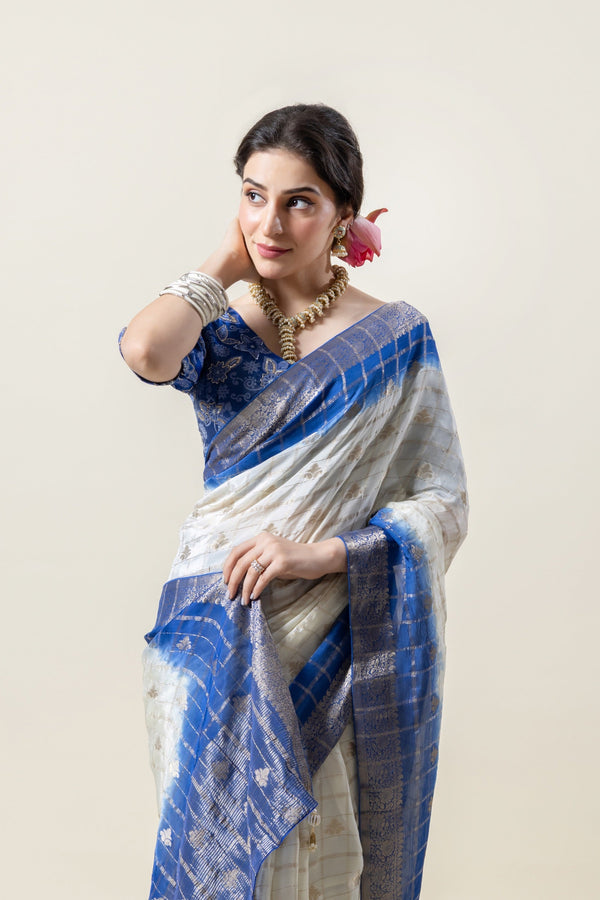 A beautiful side profile of the model in a Vanya Sarees Chanderi silk saree, highlighting the blue tie-dye and woven zari border.