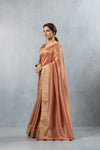 An elegant side profile of the model wearing the Vanya Sarees copper and gold Banarasi silk saree, showcasing its rich drape and lustre.