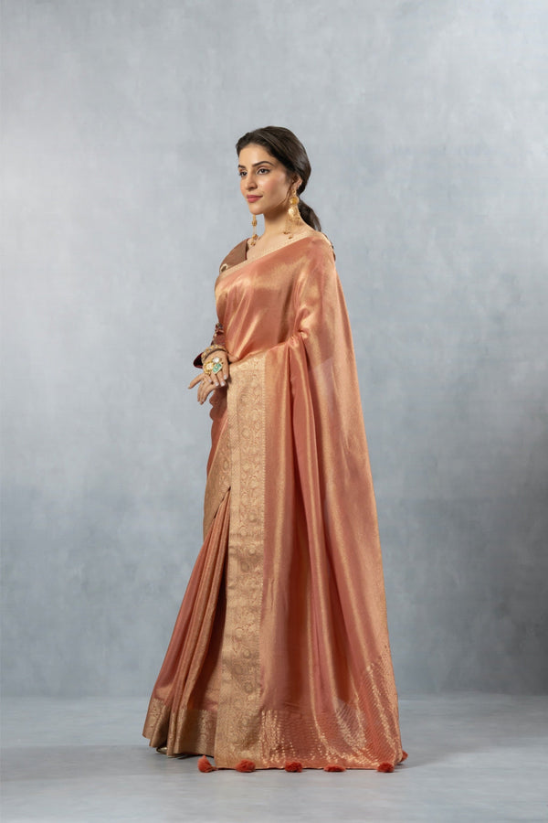 An elegant side profile of the model wearing the Vanya Sarees copper and gold Banarasi silk saree, showcasing its rich drape and lustre.