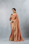 An elegant standing pose of the model in the Vanya Sarees copper rose Banarasi silk saree, perfect for a wedding or reception.
