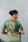 The stunning hand-embroidered back of the designer blouse from Vanya Sarees, featuring a magnificent mural of two lovebirds on a tree.