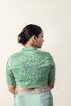 The stunning hand-embroidered mandala motif on the back of the pista green designer blouse from Vanya Sarees.