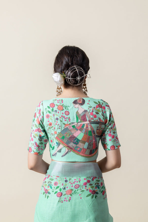 The statement back of the designer blouse from Vanya Sarees, featuring the artistic print of a lady in a garden.