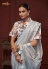 A close-up of the Vanya Sarees' ensemble, detailing the artistic print on the high collar neck blouse and the handcrafted tassels on the pallu.