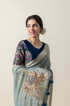 A smiling model showcasing the handcrafted elephant appliqué on the pallu of the Vanya Sarees shimmer linen saree.