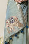 A close-up detail shot of the intricate elephant appliqué and blue tassels on the pallu of the Vanya Sarees linen silk saree.