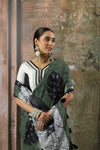 A close-up of the model wearing the Vanya Sarees green linen saree, with a clear view of the tropical leaf print on the pallu.