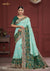 A full-length view of the model in Vanya Sarees' magnificent sea green bridal saree with a heavy, multi-color embroidered border.