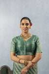 A clear front view of the Vanya Sarees readymade designer blouse in sage green, showing the V-neck and woven sleeve detail.