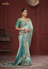 An graceful standing pose of the model showcasing the complete designer look of the Vanya Sarees green heavy embroidered ombre saree.