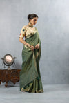 An elegant side profile of the model wearing the Vanya Sarees green crushed tissue silk saree, showcasing its beautiful lustre and drape.