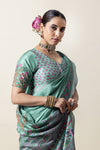 A close-up of the model wearing the Vanya Sarees green Tussar silk saree, highlighting the designer printed blouse.