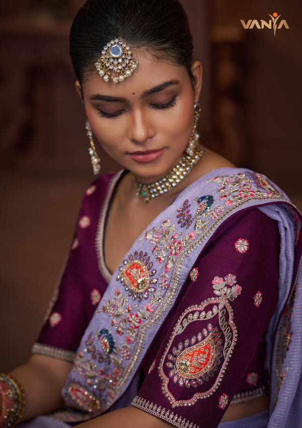 A stunning close-up of the model wearing the Vanya Sarees lavender saree, showing the intricate multi-color embroidery on the border and blouse sleeve.