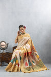 Model seated gracefully in the Vanya Sarees off-white silk saree, with the colorful Kathputli print pallu beautifully displayed.