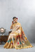 Model seated gracefully in the Vanya Sarees off-white silk saree, with the colorful Kathputli print pallu beautifully displayed.