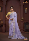 A full-length view of the model in Vanya Sarees' magnificent lavender silk saree with a heavy, multi-color embroidered border and yellow blouse.