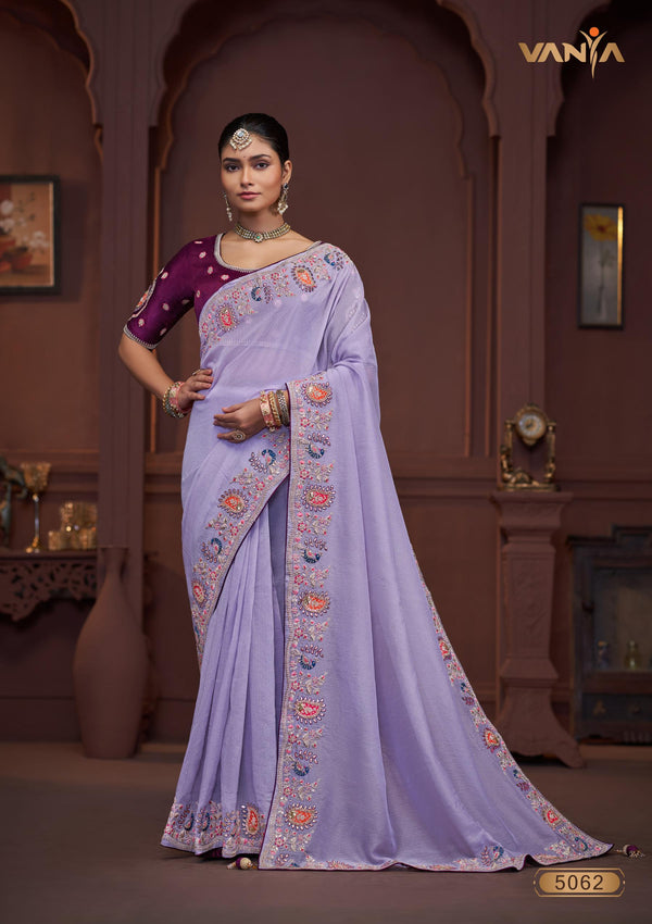 A full-length view of the model in Vanya Sarees' magnificent lavender silk saree with a heavy, multi-color embroidered border and plum blouse.