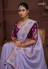 A beautiful seated portrait of the model in a Vanya Sarees lavender saree, highlighting the rich floral and peacock embroidery.