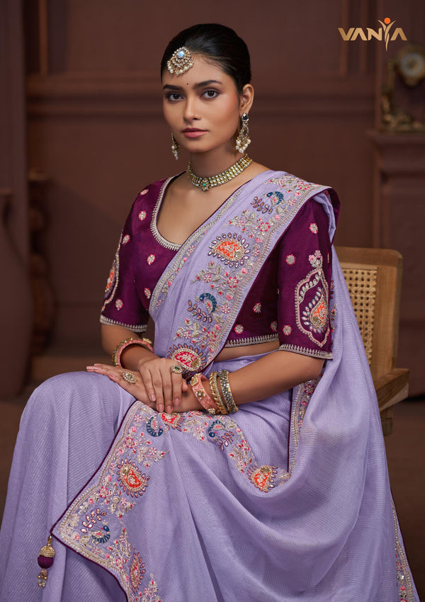 A beautiful seated portrait of the model in a Vanya Sarees lavender saree, highlighting the rich floral and peacock embroidery.