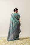 A full back view of the model in the Vanya Sarees ensemble, displaying the elaborate folk art print on the pallu and the statement blouse.