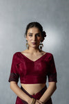 Close-up of Vanya's fitted Maroon Satin Silk V-Neck Blouse with cuff trim and statement earrings.
