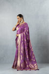 Elegant side profile of a model wearing the Vanya Sarees mauve tissue silk saree, highlighting the bold paisley motifs and shimmering fabric.