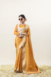 Model smiling in a stylish pose with sunglasses, wearing the complete Vanya Sarees yellow tissue silk saree and designer blouse set.