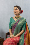 A close-up seated portrait of the model in a Vanya Sarees multi-color Bandhani saree, showing the vibrant fabrics and designer blouse.