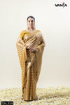 A full front view of the model in Vanya Sarees' regal mustard gold Banarasi silk saree with a woven chevron pattern.