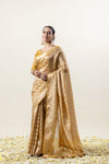 An elegant pose of the model in the Vanya Sarees mustard gold Banarasi silk saree, perfect for a wedding or festive look.