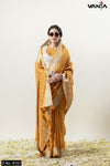 Model wearing sunglasses in a full front view of Vanya Sarees' mustard yellow woven tissue silk saree with a designer jacket blouse.