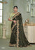 A full-length view of the model in Vanya Sarees' magnificent olive green saree with a heavy, multi-color embroidered cutwork border.