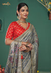 A beautiful close-up of the model in a Vanya Sarees saree, highlighting the rich Patola-inspired border and the red brocade blouse.