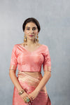 Close-up of Vanya's plain Peach Satin Silk V-Neck Blouse with gold trim on the sleeve cuff.