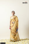 Full view of a model in a Vanya Sarees yellow linen saree featuring a Pichwai print of lotuses and a zari border.