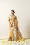 Model looking elegantly to the side in a complete festive look with the yellow Pichwai printed Vanya Sarees and traditional jewelry.