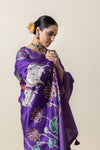 A close-up of the model showcasing the sacred cow and lotus motifs on the pallu of the Vanya Sarees purple Pichwai saree.