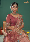A beautiful seated portrait of the model in a Vanya Sarees pink ombre saree, highlighting the rich floral embroidery on the border and blouse.