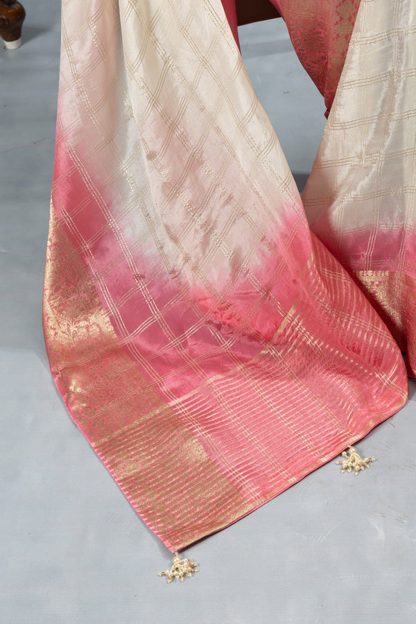 A close-up detail shot of the Vanya Sarees saree pallu, showing the pink ombre dye effect over the gold zari border and tassels.