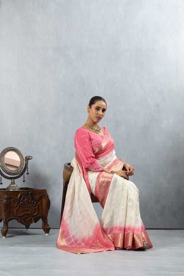 Model seated gracefully in the Vanya Sarees ivory and pink ombre saree, displaying the beautiful drape and bishop sleeve blouse.