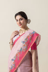 A close-up of the model wearing the Vanya Sarees pink saree, highlighting the artistic bird print on the rani pink border.
