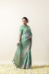 An elegant side profile of the model in the Vanya Sarees pista green Chanderi saree, showcasing its fluid drape and shimmer.